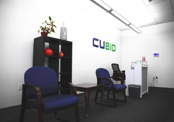 reception area with two chairs, a bookshelf, and company logo